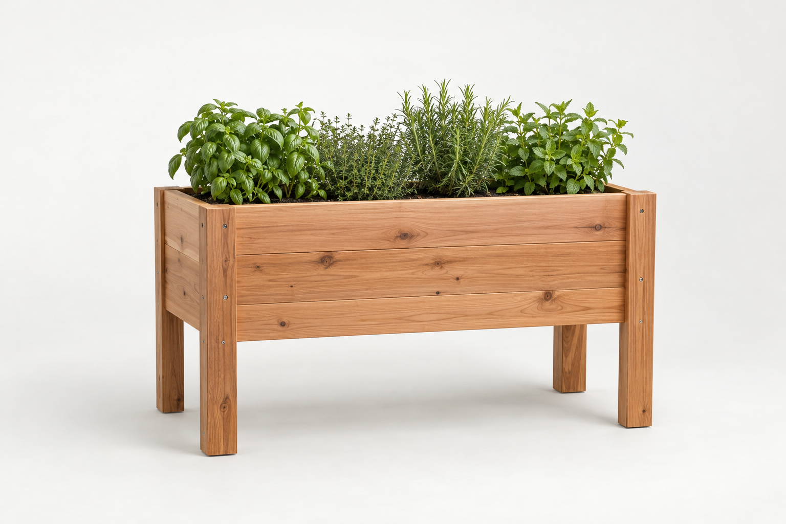 Untreated cedar planter box beside a deck railing, planted with parsley and leaf lettuce